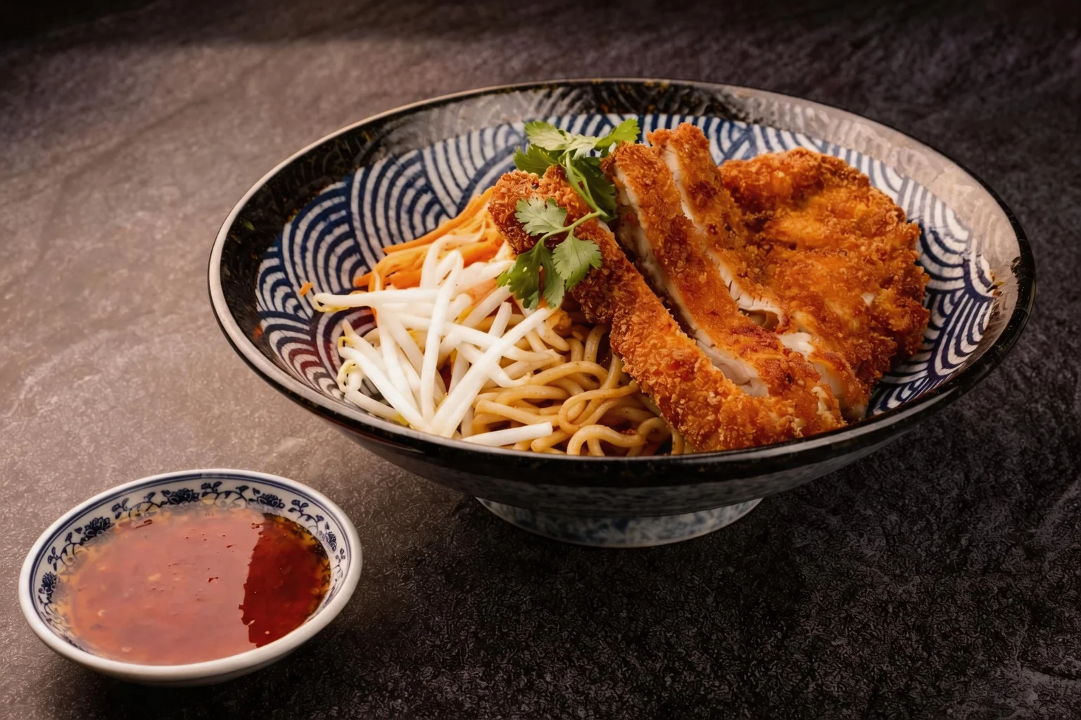 Bowl of noodles with crispy chicken, bean sprouts and coriander